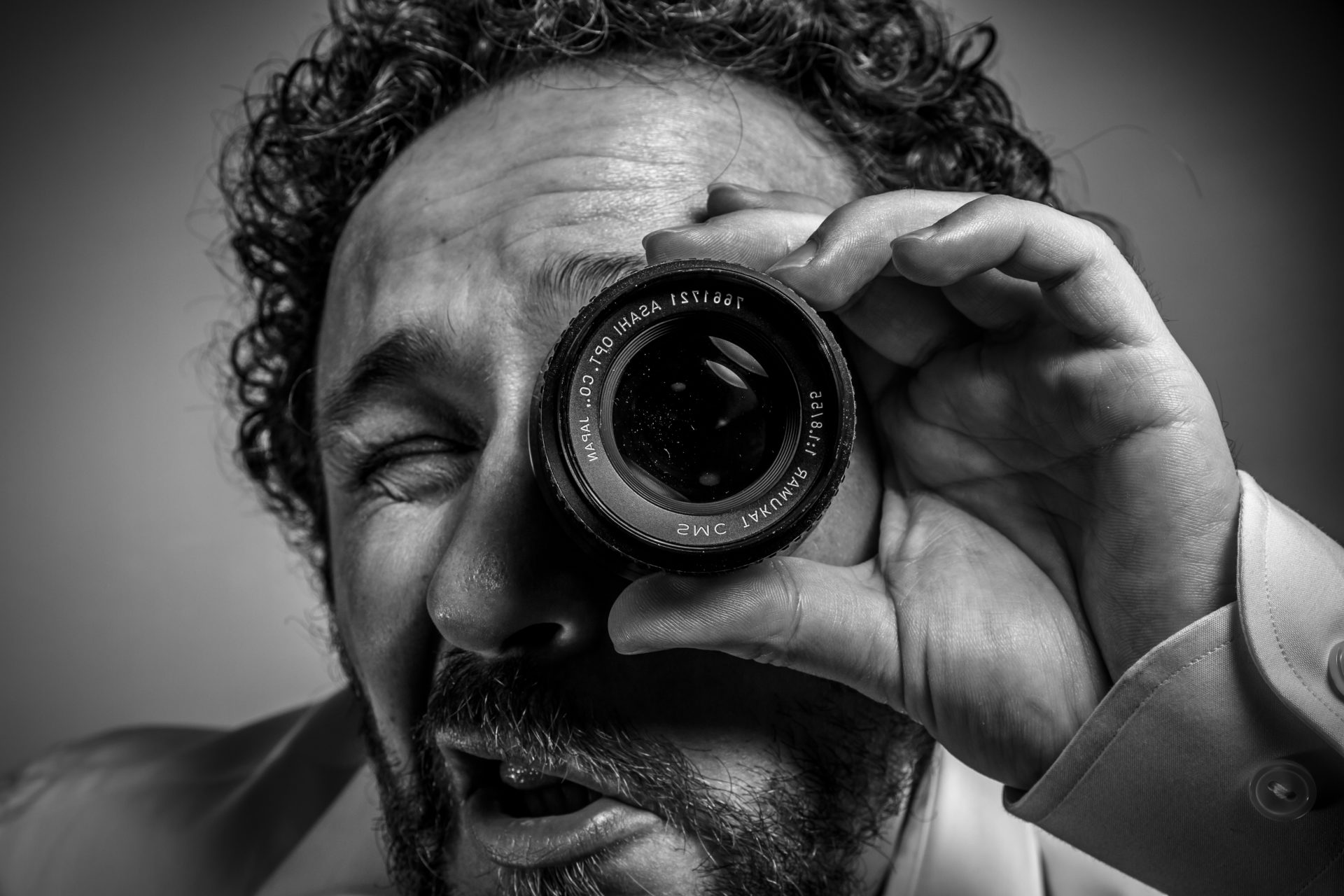 photographer with lens, man with intense expression, white shirt